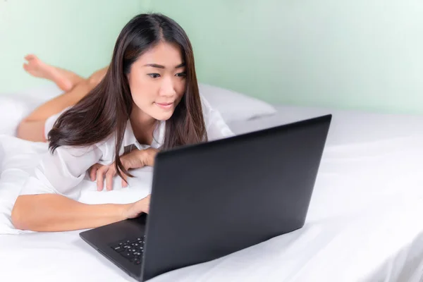 若いアジアの女性は寝室の家でノートパソコンを使用する 家庭の概念から — ストック写真