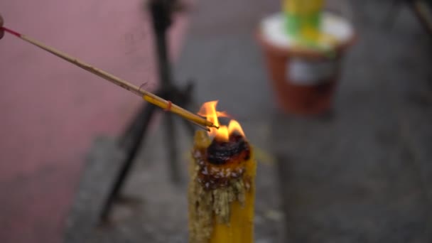 Person Zündet Räucherstäbchen Aus Kerze — Stockvideo