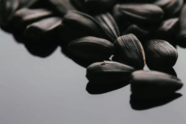 Many black sunflower seeds background close up — Stock Photo, Image