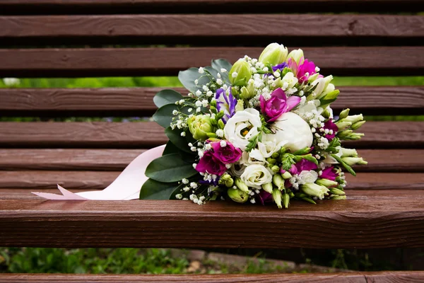 Свадебный букет на скамейке — стоковое фото