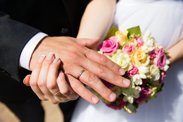 Bride and groom hands with wedding rings