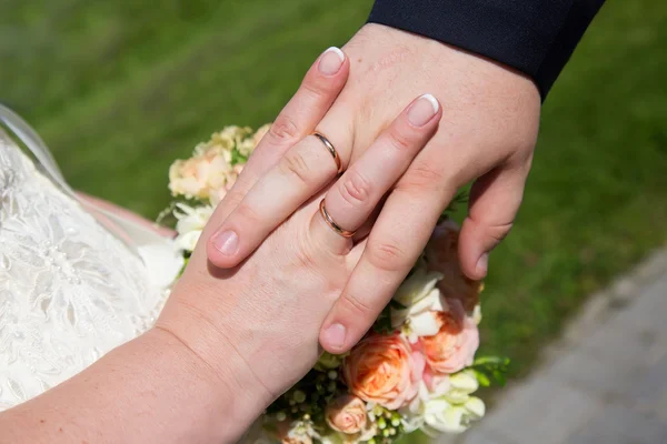 Noiva e noivo mãos com anéis de casamento — Fotografia de Stock