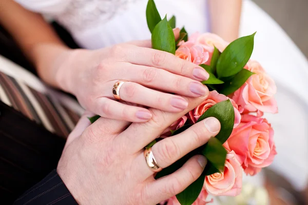 Bruid en bruidegom handen met bruiloft ringen — Stockfoto