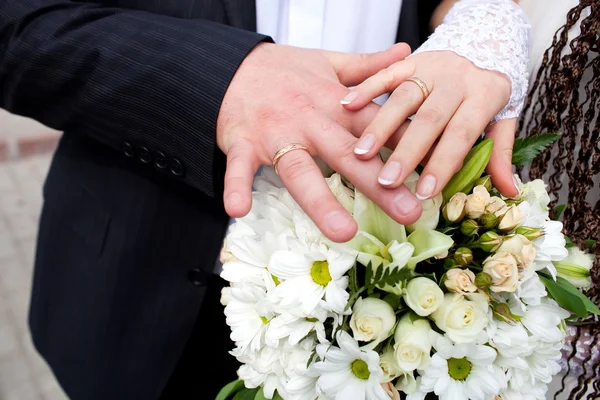 Bruid en bruidegom handen met bruiloft ringen — Stockfoto