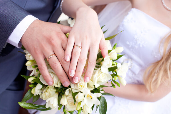 Bride and groom hands with wedding rings