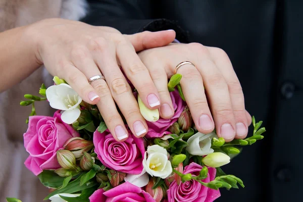 Bruid en bruidegom handen met bruiloft ringen — Stockfoto