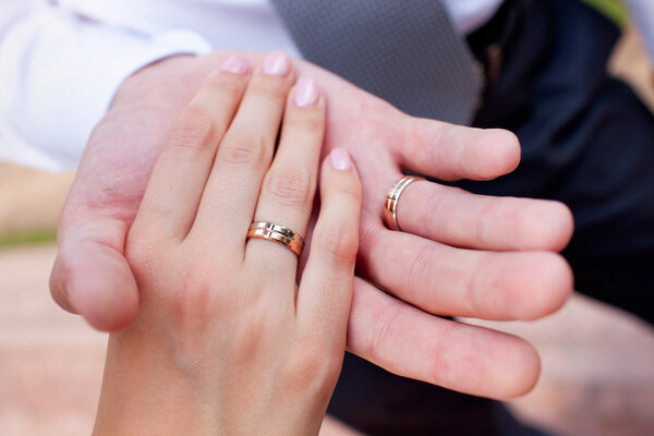 Руки жениха и невесты с кольцами
