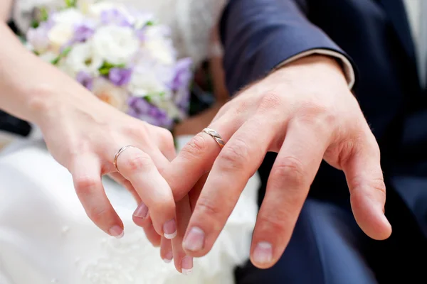 Nevěsta a ženich ruce s kroužky — Stock fotografie