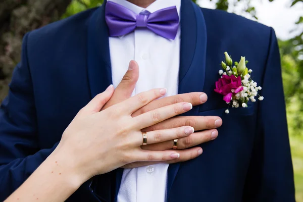 Boutonnière de mariage et la main de la mariée — Photo