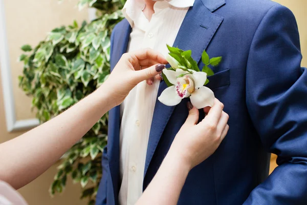 Невеста помогает жениху с бутоньеркой — стоковое фото