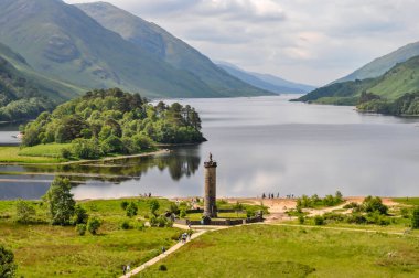 İskoçya 'daki Loch Shiel' e bakan Glenfinnan Anıtı 'nın manzarası. Bir grup turist bölgeyi keşfediyor.