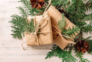 Köknar dallı 2 Noel hediyesi kutusu, beyaz ahşap arka planda koniler, üst manzara.