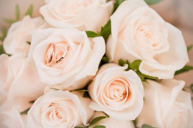 Güzel bir buket beyaz gül ve iki altın alyans.