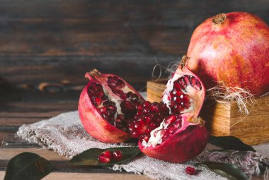 Koyu ahşap zemin üzerinde olgun kırmızı nar.