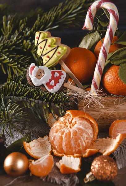 Mandalina, mandalina, lolipop, altın Noel baloları, köknar dalları, karanlık bir yerde. 