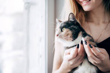 Gün boyunca pencerenin kenarında oturan bir beyaz kadın.