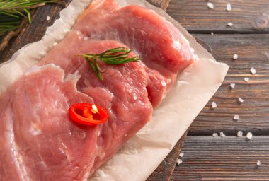 Biberiyeli çiğ domuz filetosu, ahşap arka planda biber, et