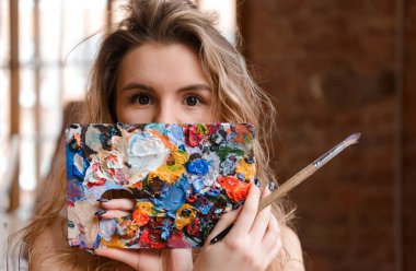 Odasında boya olan bir beyaz sarışın kadın.