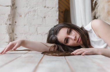 Uzun saçlı beyaz, hoş bir kadın kafasını tahta pencere pervazına koydu.