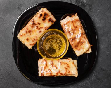 Beyaz tortilla, balkabağı ve tereyağlı. Siyah bir tabakta, üst tarafta.