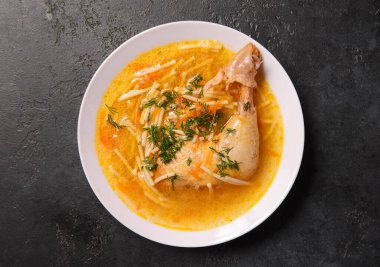 Tavuklu erişte çorbası ve siyah arka plan manzaralı otlar.