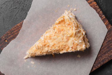 1 dilim Napolyon keki tahtada en üstte, tatlı