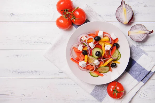 Talerz Sałatki Greckiej Warzywami Feta Pomidorami Oliwkami Białym Ręczniku Jasnodrewnianym — Zdjęcie stockowe