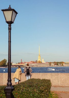 people on the banks of the Neva River against the background of the Peter and Paul Fortress in St. Petersburg September