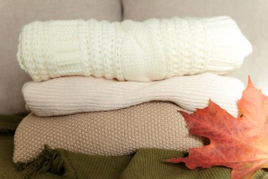 sweater stack, orange maple leaf, autumn