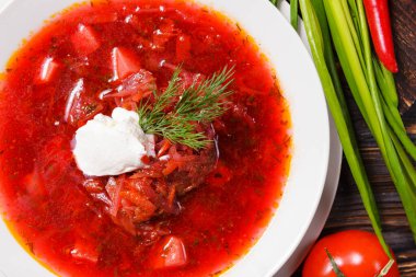 Ekşi kremalı borş ve dereotlu beyaz tabak, soğan, domates