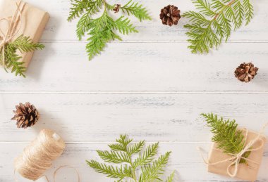 Köknar dalları, köknar kozalakları, hediye kutusu, beyaz ahşap bir bobin makarası, Noel.