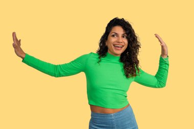 Genç bir kadın büyük bir gülümsemeyle dans ediyor ve kollarını açıp neşe ve heyecan ifade ediyor.