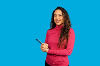 Gülümseyen bir kadın mavi arka planda bir tablet tutarken iş dünyasına teknoloji getiriyor.