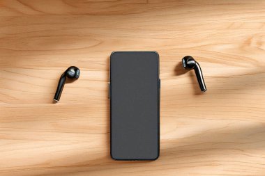 Kablosuz kulaklıklı siyah akıllı telefon, müzik, podcast ya da sesli kitap dinlemeyi öneriyor.