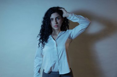 Poz veren, stres, endişe ya da derin düşünceleri olan genç bir kadın.