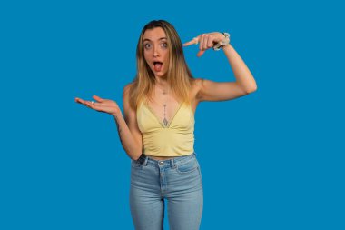 Elinde beyaz bir hap tutan genç bir kadın şaşırdı ve kafasını bir fikirle gösterdi.