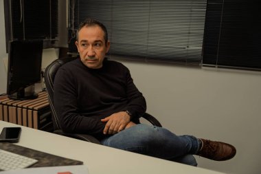 Orta yaşlı işadamı ofiste gelecek stratejileri düşünüyor, planlıyor ve tasarlıyor.