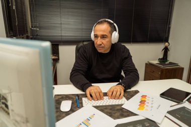 İş verilerine odaklanan ve bir bilgisayar klavyesine yazan adam