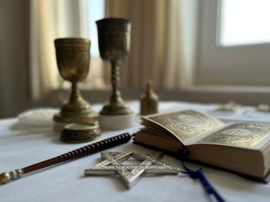 Beyaz bir masaya yerleştirilmiş Yahudi dini nesneler, aralarında bir torah ve David 'in yıldızı da var.