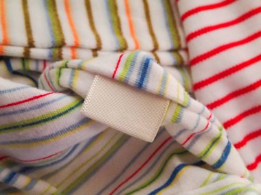 Renkli desenli ve boş etiketli pamuk kumaş tekstil giysilerini kapat.