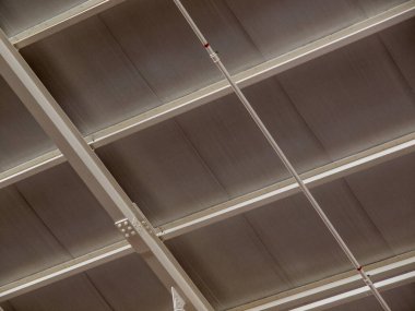 Metal kiriş parmaklık tavan yapısı ve endüstriyel bir binanın boru hattı..