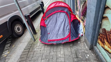 Evsiz biri şehirde bir çadırda uyur.