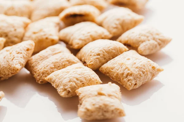 Mısır gevreği yastıklar üzerinde beyaz arka plan doldurarak çikolata ile