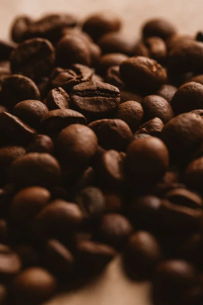 Dunkle Kaffeebohnen in Nahaufnahme auf hellem Papier — Stockfoto