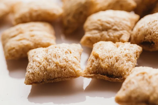 Mısır gevreği yastıklar üzerinde beyaz arka plan doldurarak çikolata ile