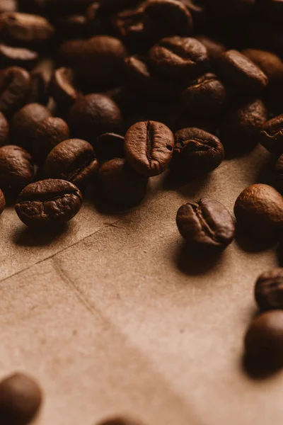 Dark coffee beans close-up on light paper — Stock Photo, Image