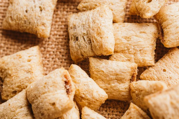 Mısır gevreği yastıklar üzerinde çul arka plan doldurarak çikolata ile