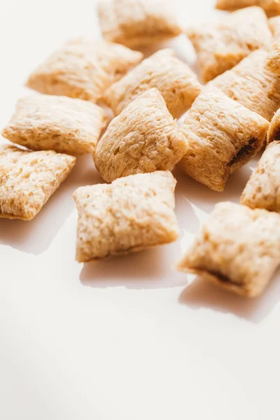 Mısır gevreği yastıklar üzerinde beyaz arka plan doldurarak çikolata ile