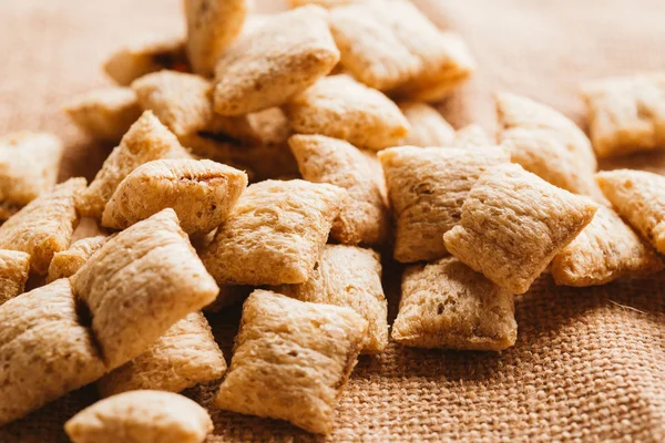 Mısır gevreği yastıklar üzerinde çul arka plan doldurarak çikolata ile