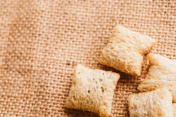 Mısır gevreği yastıklar üzerinde çul arka plan doldurarak çikolata ile